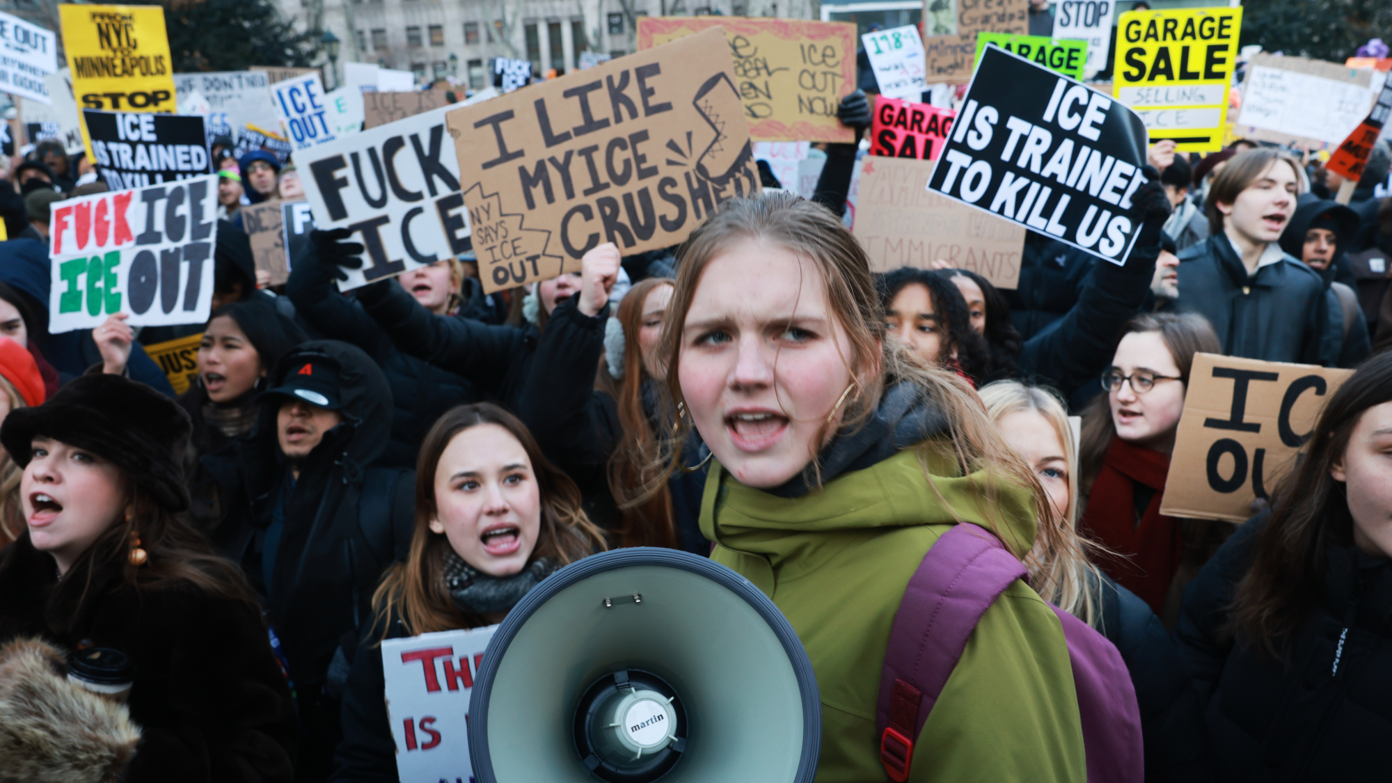Hundreds of people, including students, attend a rally in lower Manhattan as part of a 'National Shutdown" event against ICE on January 30, 2026, in New York City. Young girl holds a megaphone. 