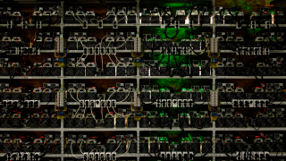 Shelves filled with small machines and wires, lit up in different colors.