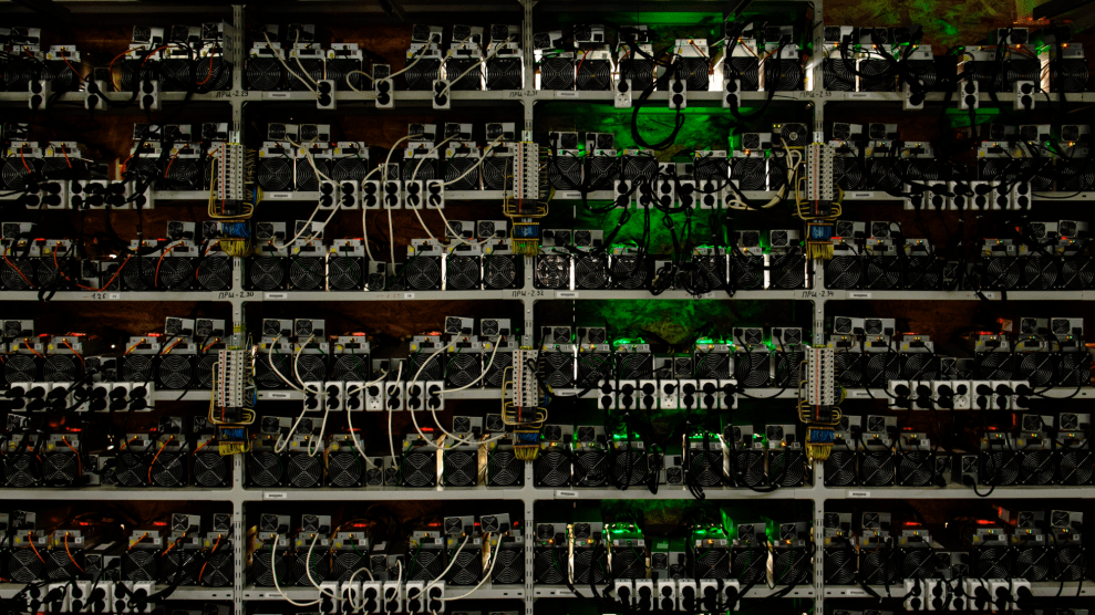 Shelves filled with small machines and wires, lit up in different colors.