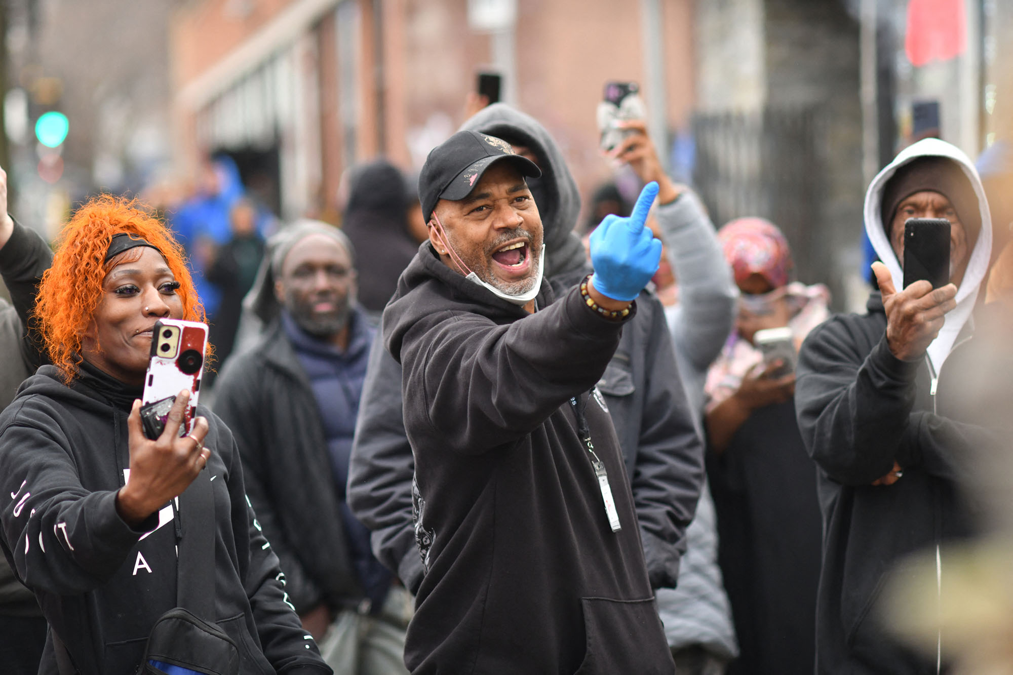 A man wearing a blue glove flips off federal agents.