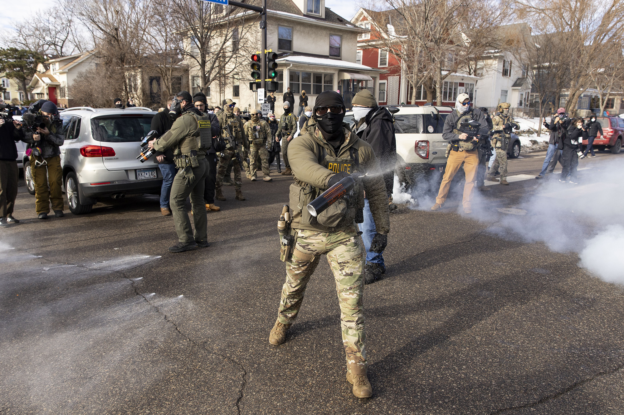 Federal agent sprays a crowd with pepper spray.