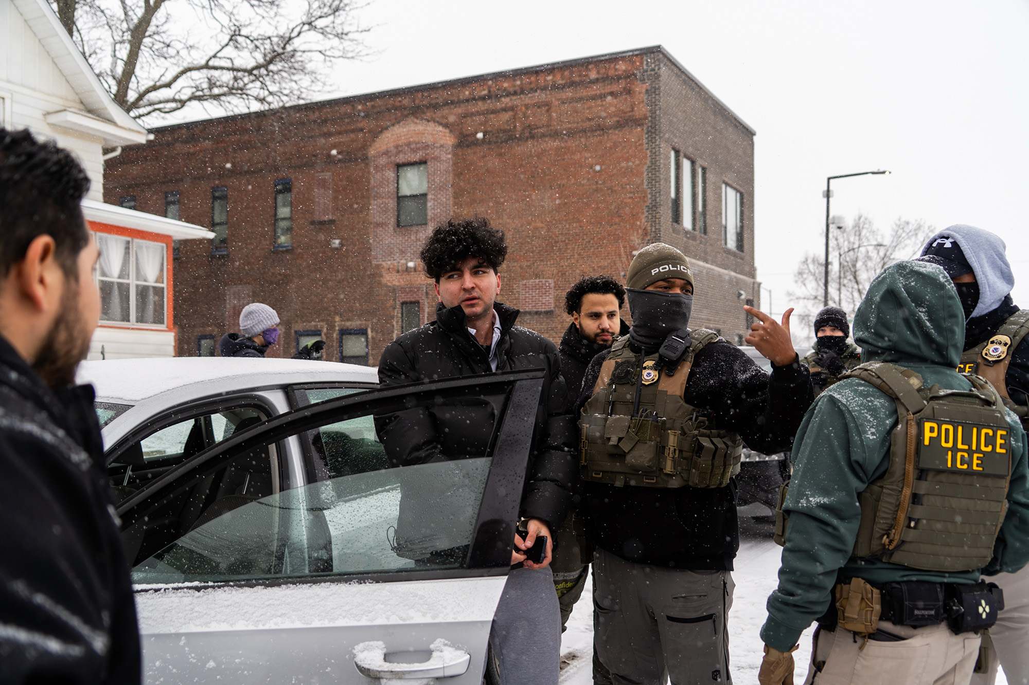 A man is detained and surrounded by a number of federal agents.