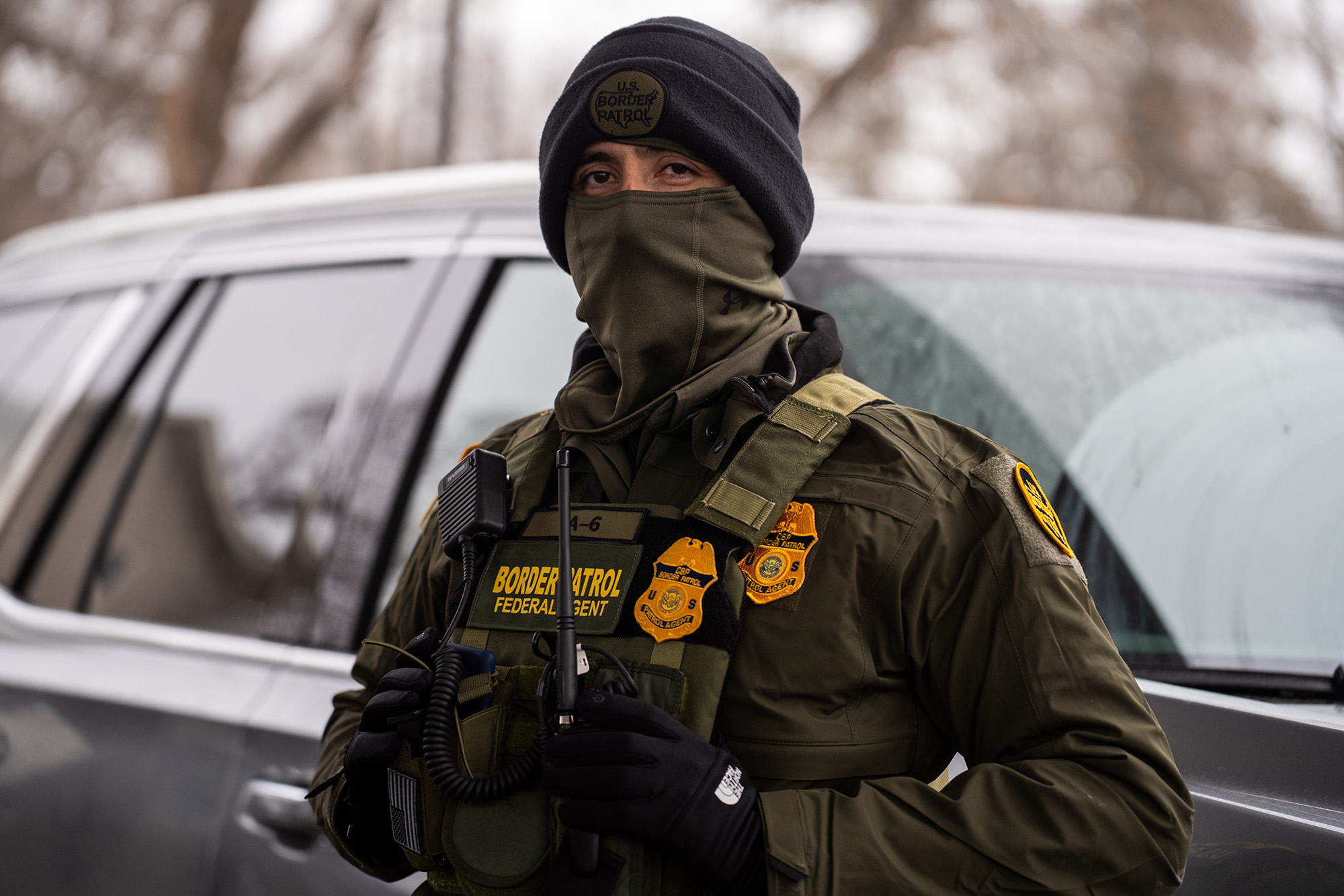 Masked Border Patrol agent looking at photographer.