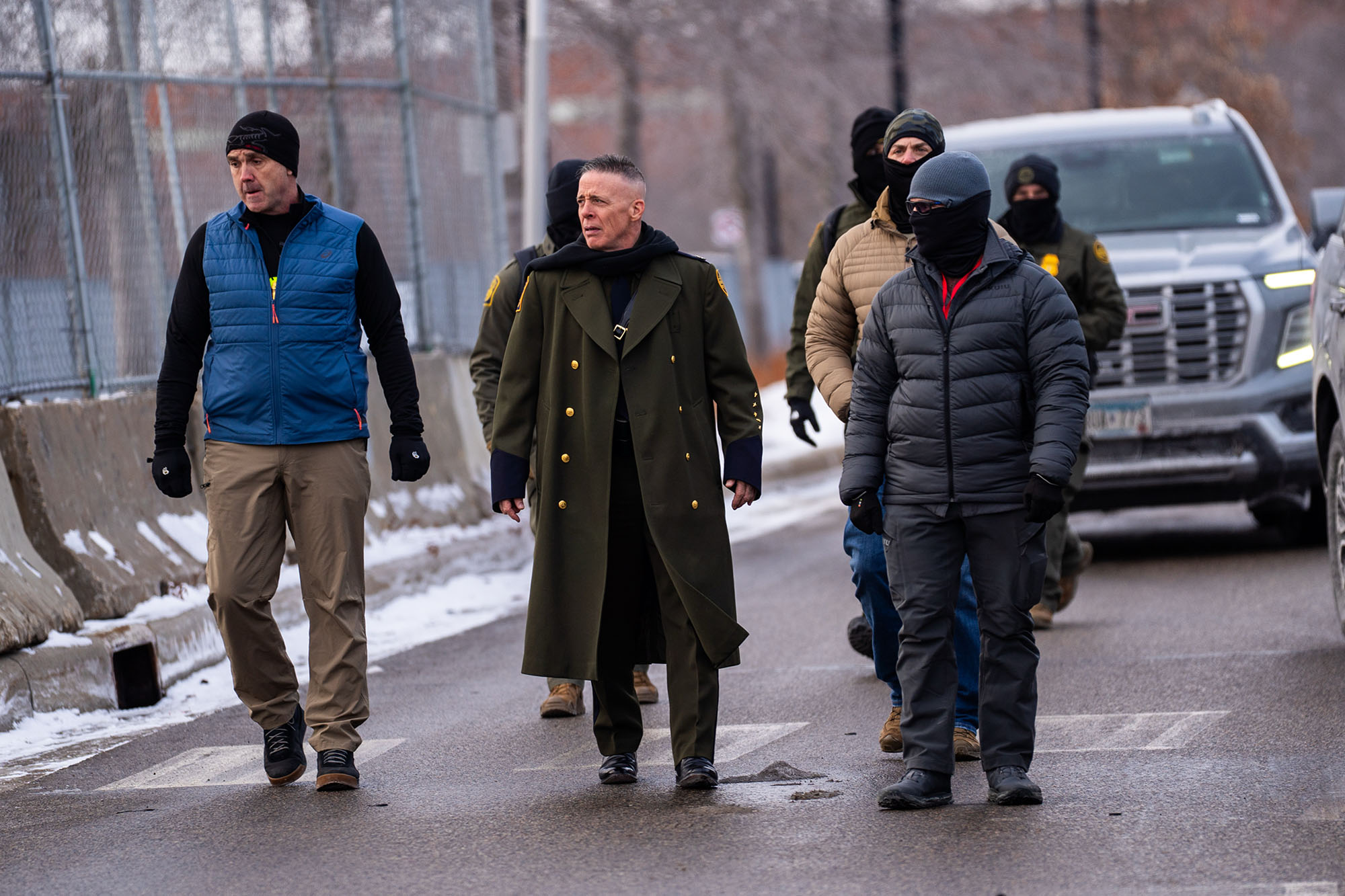 Gregory Bovin walks down a driveway with a group of federal agents.