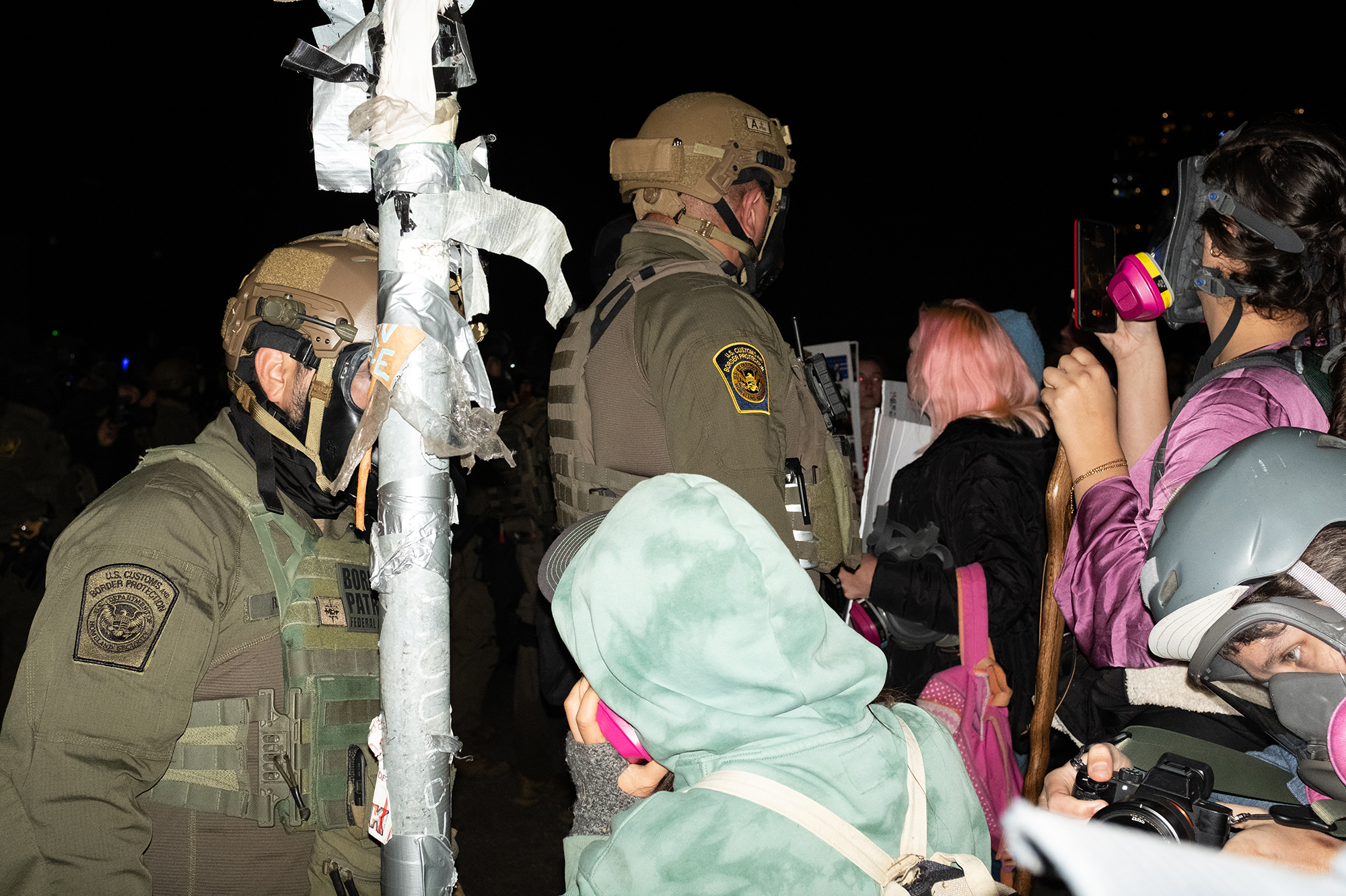 Jumble of federal agents and protesters face off at night.