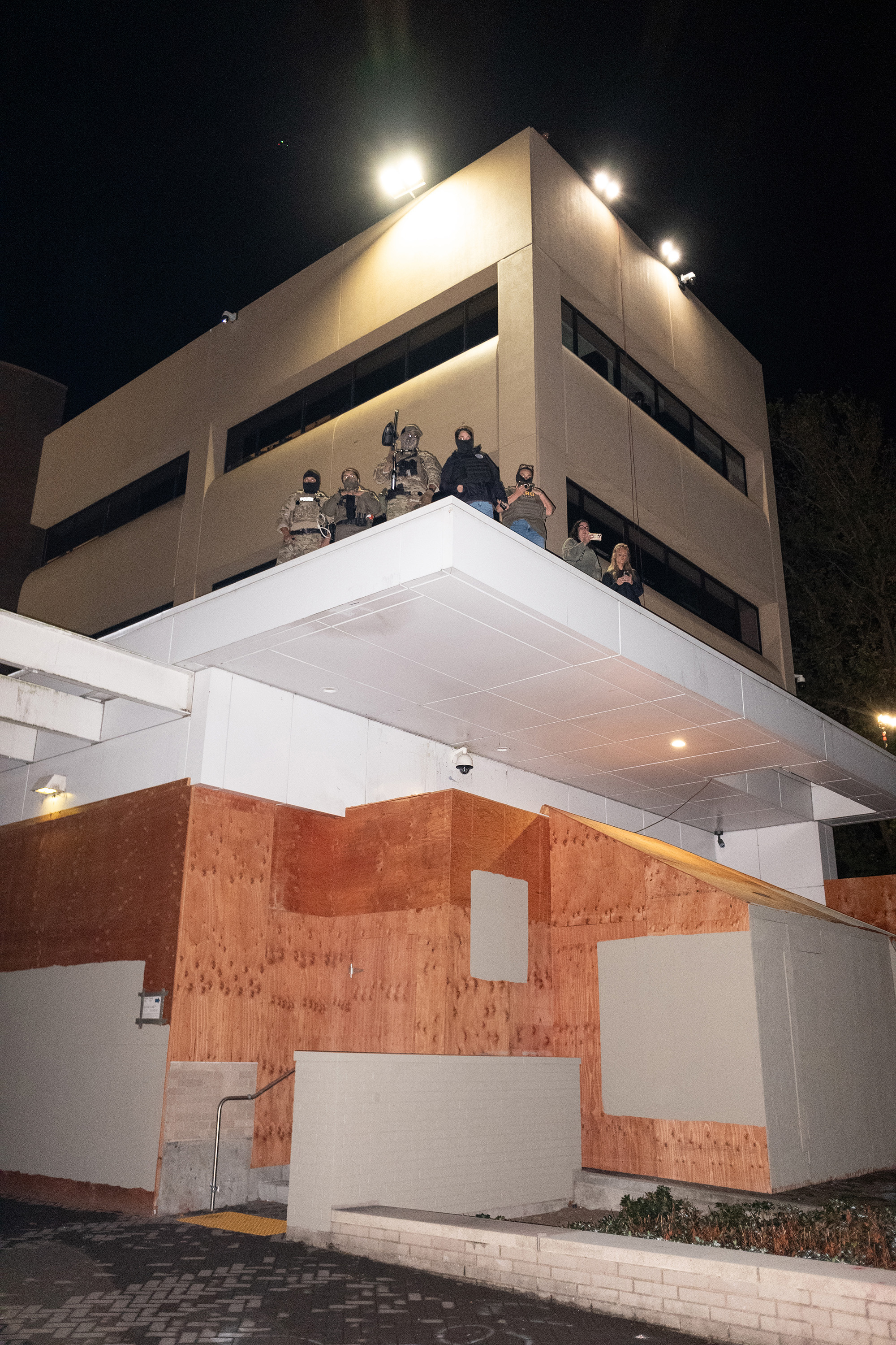 Federal agents on the roof of a building at night.