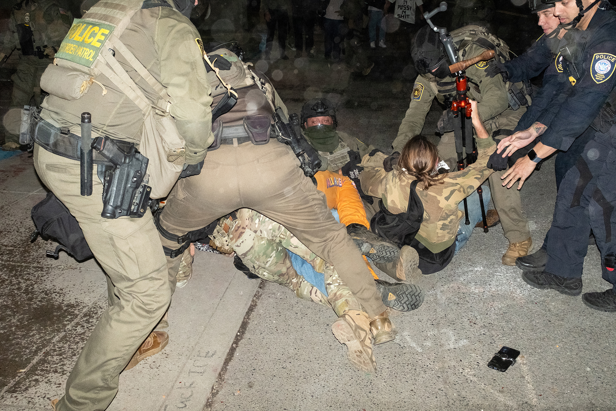 Federal agents scuffle with protesters.