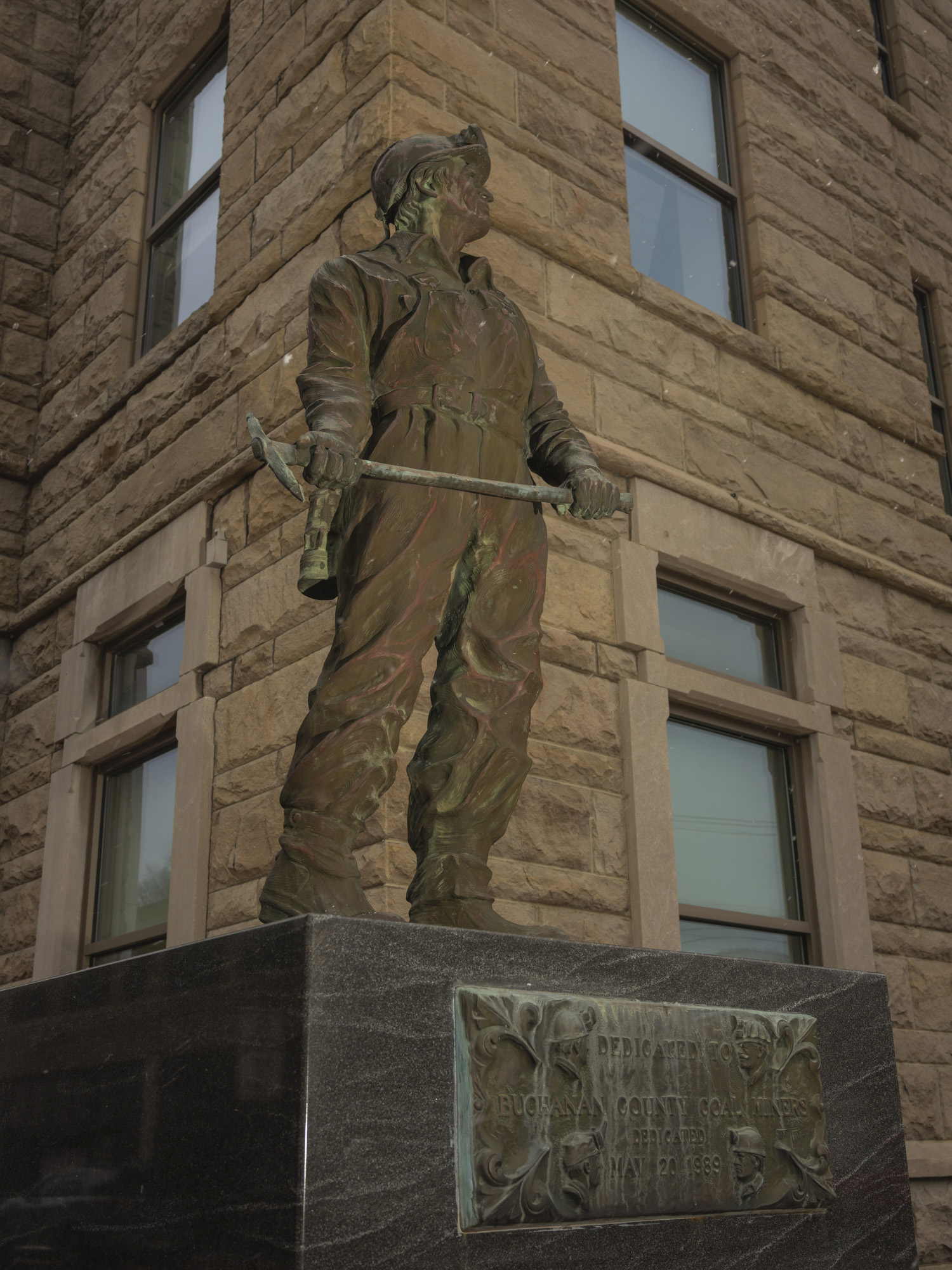 Statue of a coal miner wearing a hard hat and holding a pickax
