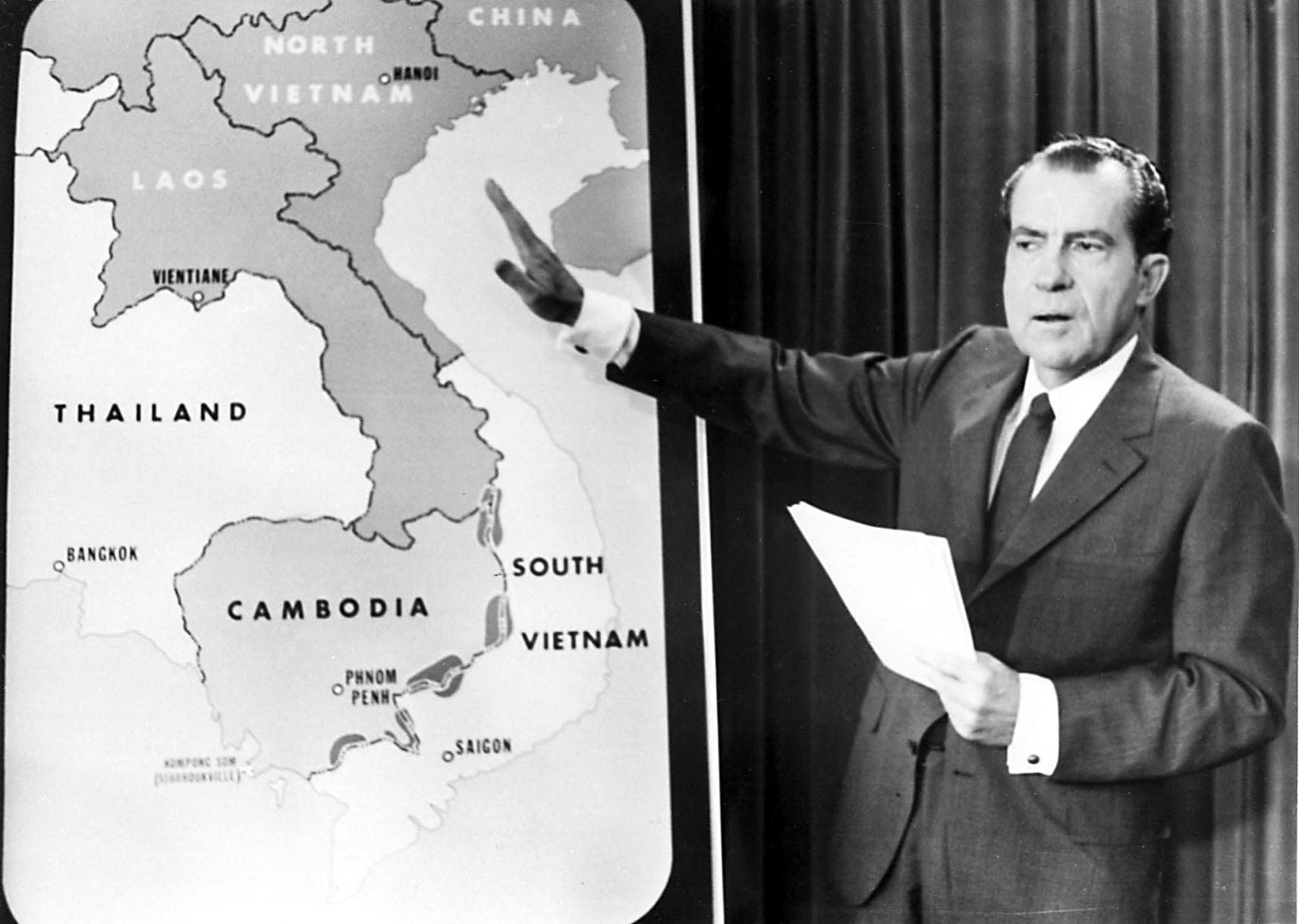 Richard Nixon gesturing to a map of Southeast Asia.